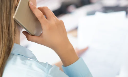 closeup-woman-talking-smartphone-holding-papers